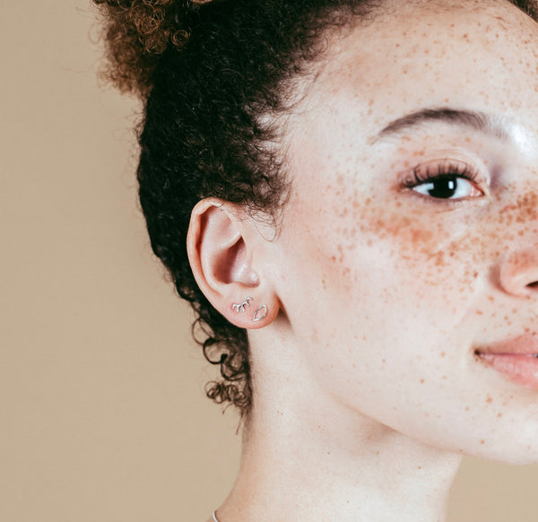 a closeup shot of our model wearing the silver open eye studs